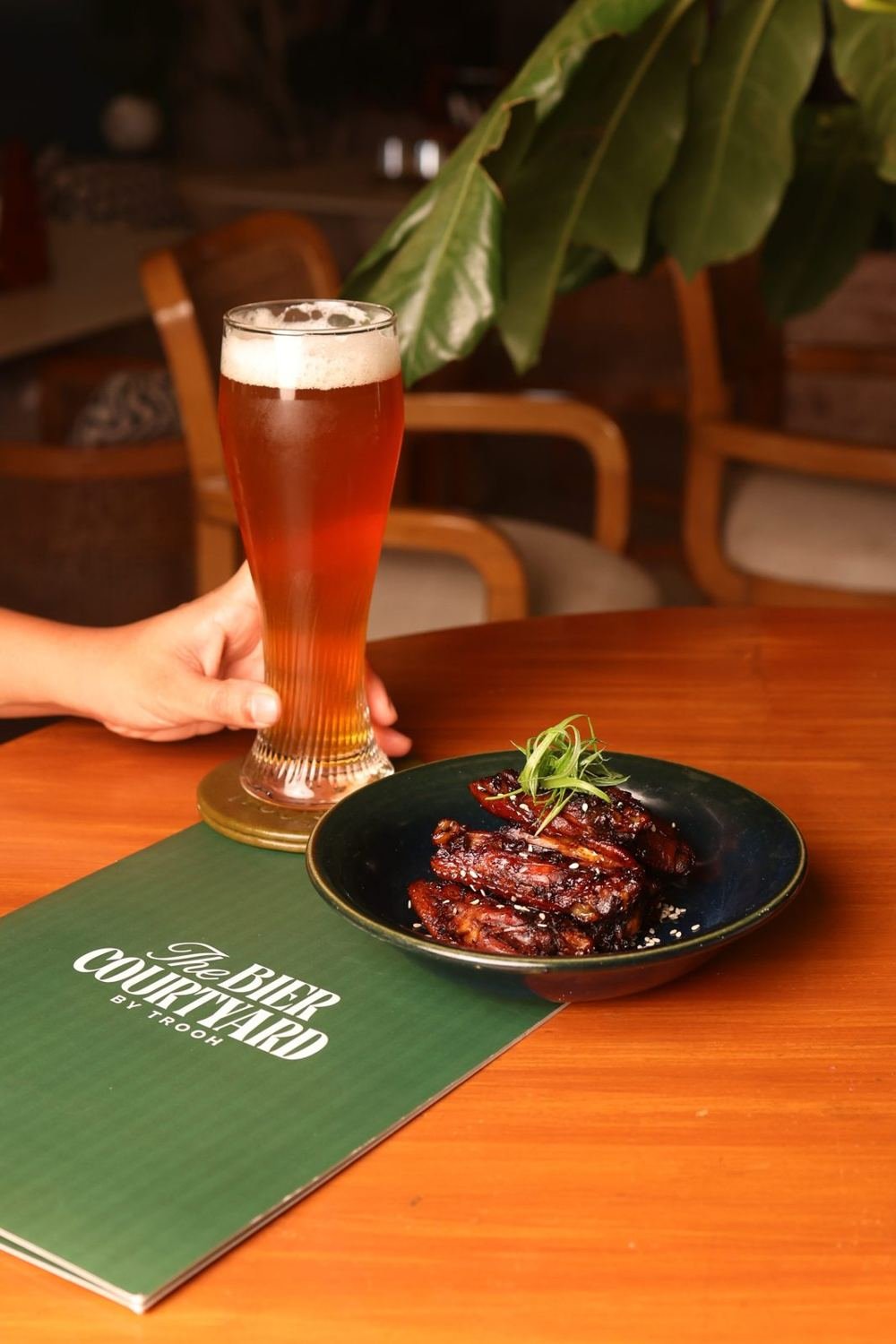Glass of craft beer with wings and TBC menu at the beer garden in Kalyani Nagar