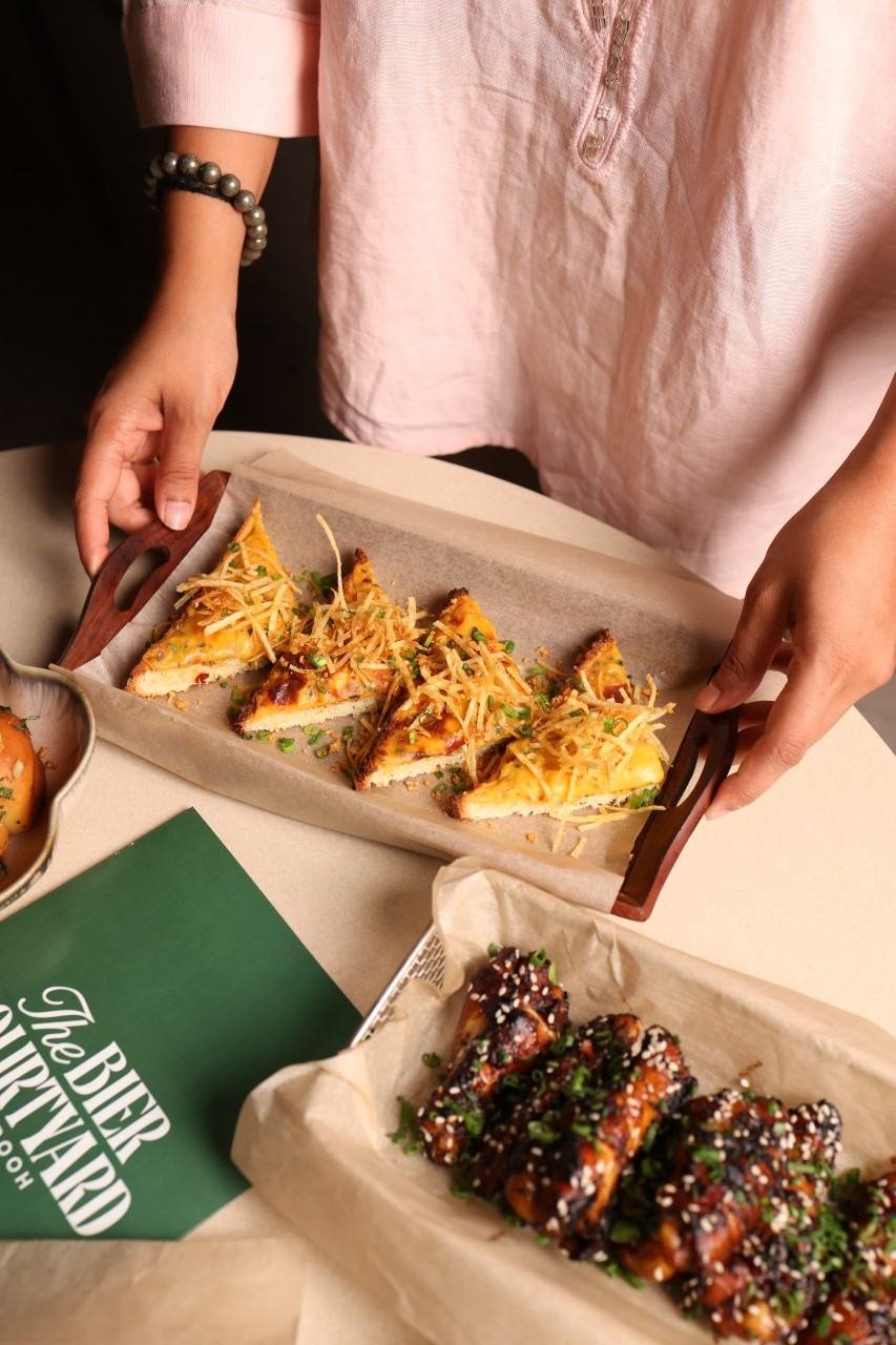 Sharing plates of wings and snacks on a table at TBC pub, Pune
